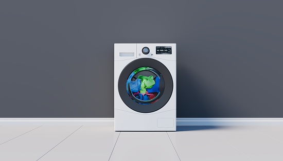 Washing machine with clothes inside standing on a tile against a gray background. 3d render