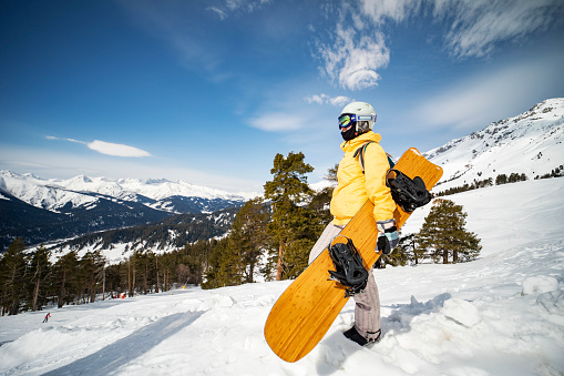 Young adult woman snowboarding in mountains