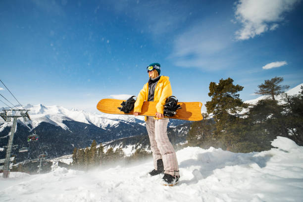 молодая взрослая женщина на сноуборде в горах - ski resort winter ski slope ski lift стоковые фото и изображения