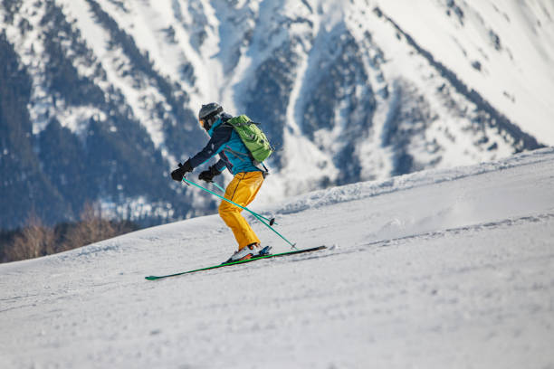 istock Young adult man skiing in mountains 1423275892