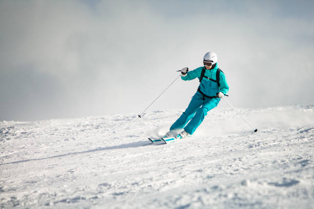 jeune femme adulte skiant en montagne - skiing sports helmet powder snow ski goggles photos et images de collection