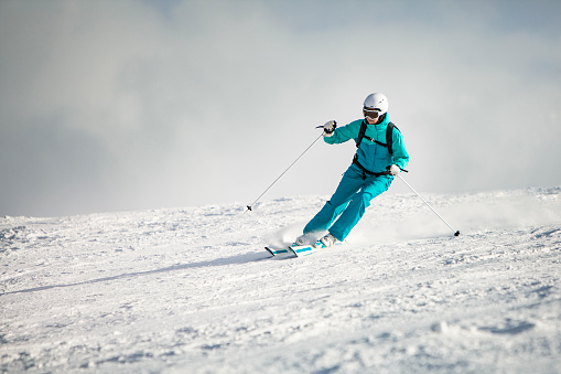 Young adult woman skiing in mountains
