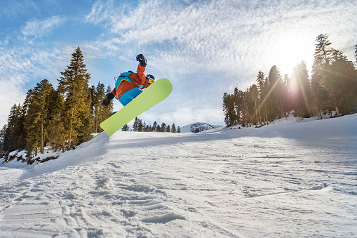 Young adult man snowboarding in mountains