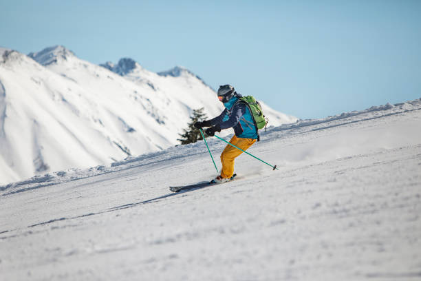 istock Young adult man skiing in mountains 1423276150