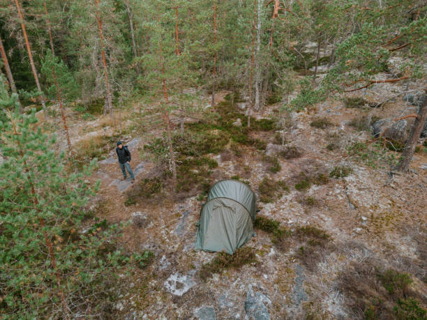 Yellow tent at the Kirnukangas campfire site in Repovesi National Park, Kouvola, Finland, with a lean-to shelter in the background.