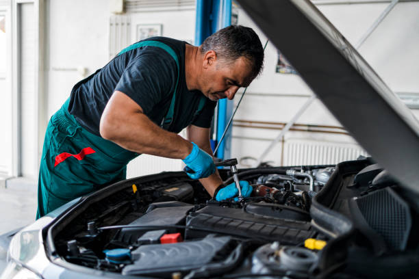 Auto mechanic service and repair Professional car service mechanic worker standing in front of car engine open hood and working. auto repair shop stock pictures, royalty-free photos & images