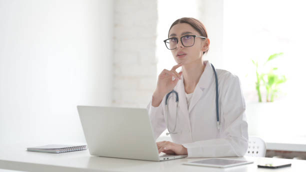 istock Female Doctor Thinking while Working on Laptop in Office 1423278530
