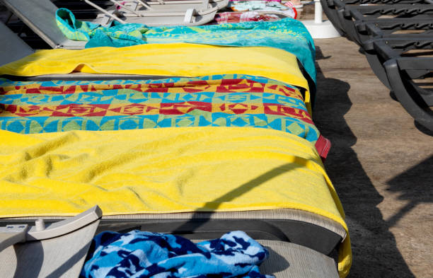 Put down towels Put down towels to reserve sunbeds at the pool area put down stock pictures, royalty-free photos & images