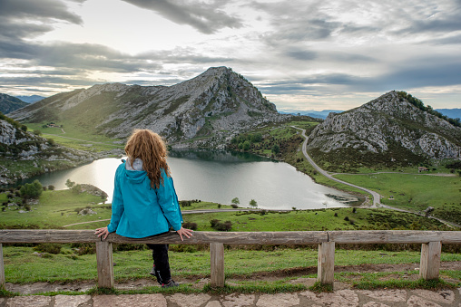 A young woman looking at the beautiful lake Covadonga in Asturias, Spain