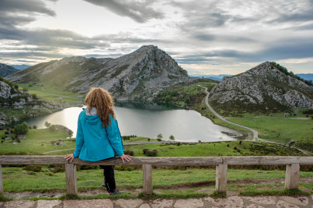 uma jovem olhando para o lindo lago covadonga em astúrias, espanha - covadonga - fotografias e filmes do acervo