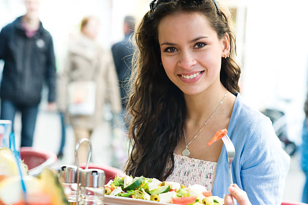 istock Young smiling woman with fork in hand behind table 142328239
