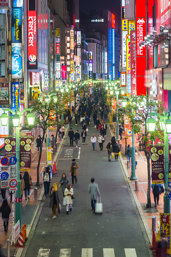 High angle view down the busy pedestrianised streets of Shinjuku, illuminated by the neon lights of this popular shopping district in the heart of Tokyo, Japan’s vibrant capital city.