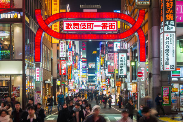 Tokyo neon nights crowds walking through Kabukicho entertainment district Japan Neon lights and illuminated billboards of Shinjuku glittering at night above crowds of shoppers in the heart of Tokyo, Japan’s vibrant capital city. shibuya district stock pictures, royalty-free photos & images