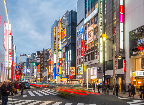 Neon lights and illuminated billboards of Shinjuku glittering at night above crowds of shoppers in the heart of Tokyo, Japan’s vibrant capital city.