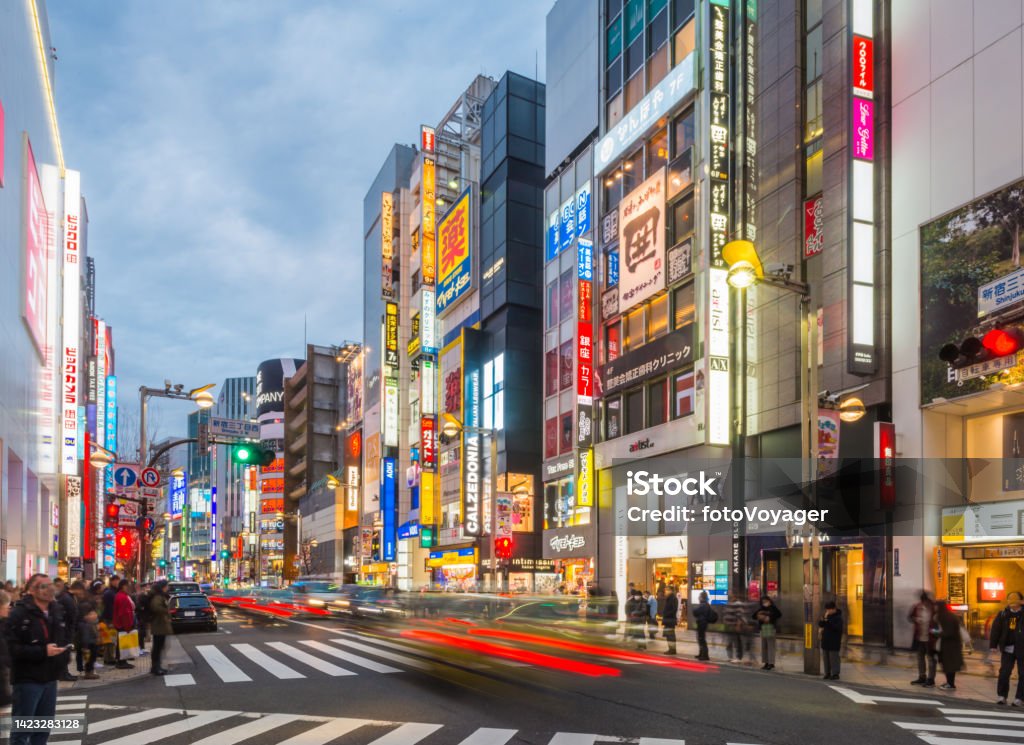 Tokyo neon nights crowded shopping streets Shinjuku traffic Japan Neon lights and illuminated billboards of Shinjuku glittering at night above crowds of shoppers in the heart of Tokyo, Japan’s vibrant capital city. City Stock Photo