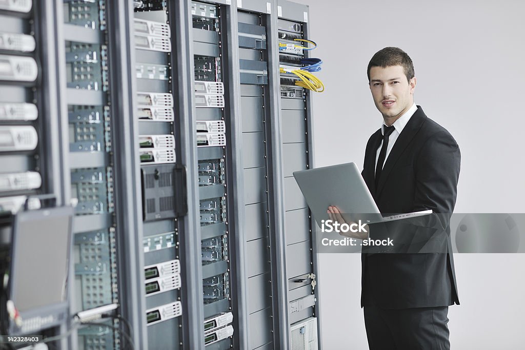 Homme d'affaires avec ordinateur portable dans la salle du serveur réseau - Photo de Adulte libre de droits