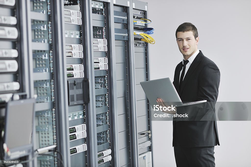 Empresário com laptop na sala do servidor de rede - Foto de stock de Adulto royalty-free