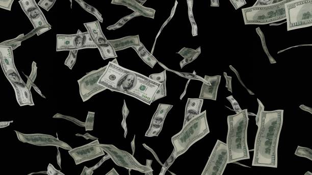 istock 100 Dollar bills falling down. Banknotes isolated on black background. 1423284559