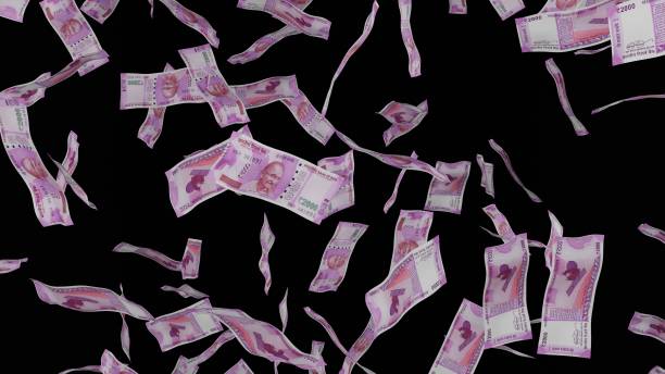 istock 2000 Indian Rupee bills falling down. Banknotes isolated on black background. 1423284601
