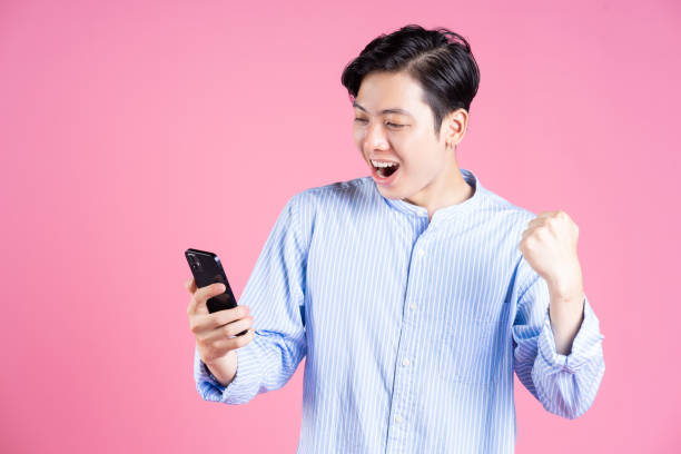 istock Photo of young Asian man using smartphone on background 1423285114