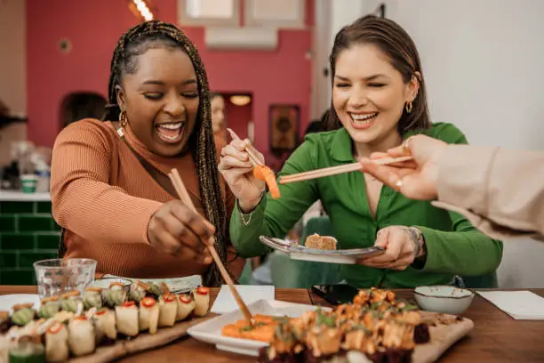 Photo of Friends enjoying sharing Vegan Sushi in a local restaurant