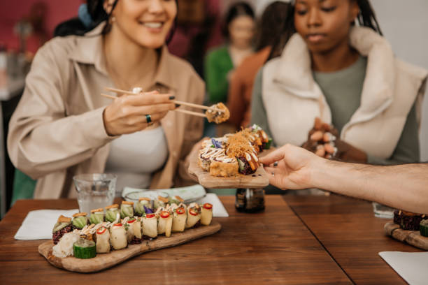 friends enjoying sharing vegan sushi in a local restaurant - buffet japanese cuisine lifestyles ready to eat imagens e fotografias de stock