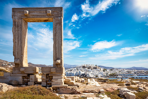 The famous gate of Naxos island, so called Portara from the temple of Apollon, in front of the whitewashed houses of the city, without people, Cyclades, Greece