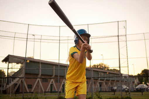 Baseball girl on a diamond with a baseball bat