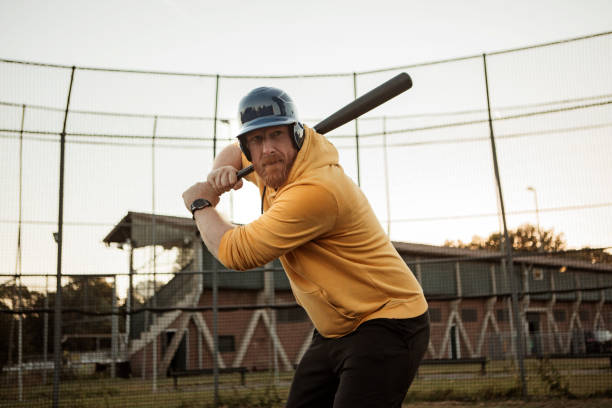 istock Overweight middle aged man on a diamond with a baseball bat 1423287238