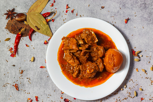 selective focus of delicious Indian style mutton curry with a decorative background.
