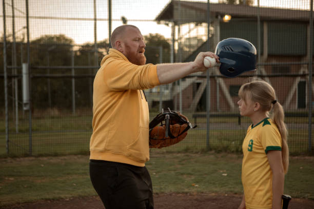 padre e figlia di baseball che lavorano duramente durante una sessione di allenamento di softball - baseball player baseball men softball foto e immagini stock