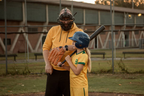 istock Baseball father and daughter working hard during a softball coaching session 1423287289