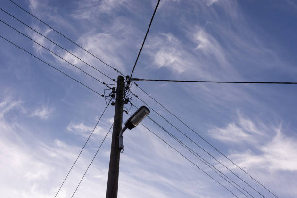 istock Wooden power pole against blue sky with clouds 1423288273