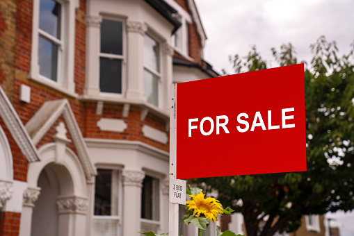 For sale sign in yard of house