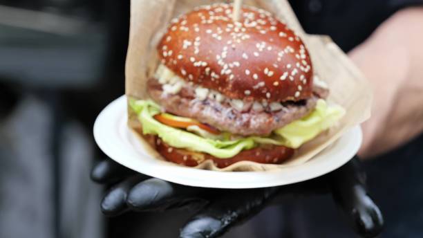 istock Yummy juicy burger with fresh ingredients on chefs hands 1423290141