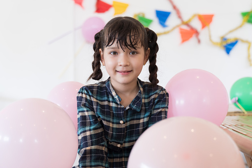 Closeup of asian child girl play with pink balloon in party at home