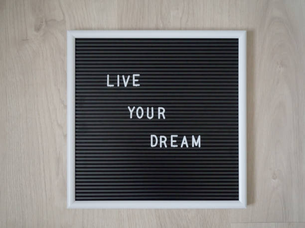 istock Board with positivism message. Message to live for our dreams and goals 1423291147