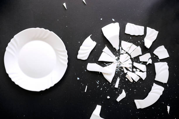 istock Whole and shuttered white plates on a black background 1423292770