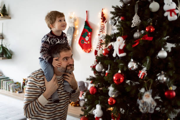 istock Father and his toddler son decorating a Christmas tree together 1423301663