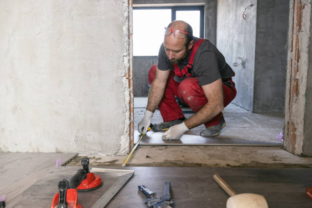 istock Professional builder measuring and leveling the tiled floor 1423304067