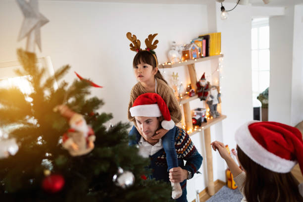 istock Multiracial family decorating Christmas tree together 1423304387