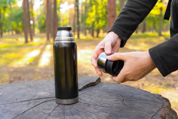 istock Male hands split thermos flask cups in the woods 1423306399