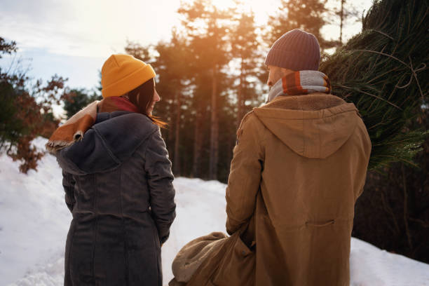 istock Unrecognizable couple carrying a Christmas tree, they found in forest 1423306650