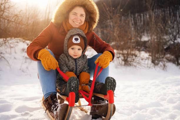 istock Mother and son, sledding on a sled in forest 1423306835