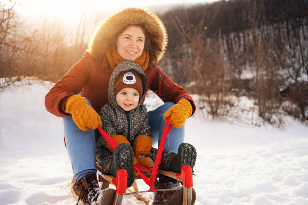 istock Mother and son, sledding on a sled in forest 1423306836