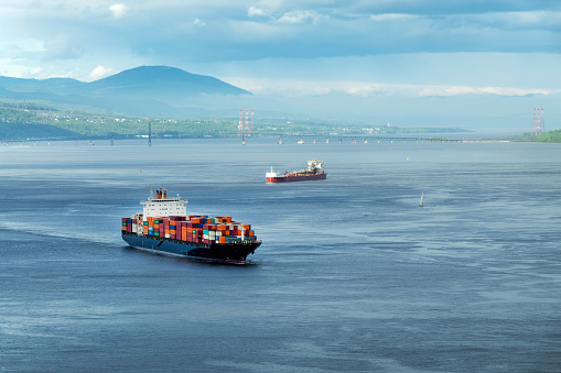 A container ship passes beneath a suspension bridge as it departs for Europe.