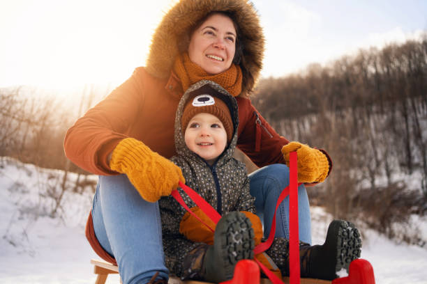 istock Mother and son, sledding on a sled in forest 1423306940