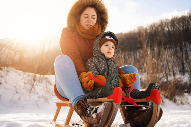 istock Mother and son, sledding on a sled in forest 1423307055