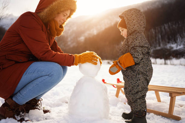 istock Caucasian mother and son, making a snowman 1423307060