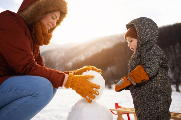 istock Caucasian mother and son, making a snowman 1423307188